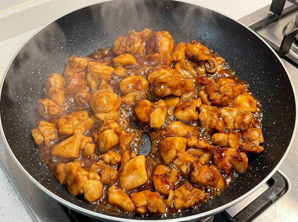 프라이팬에서 걸쭉한 소스와 함께 끓고 있는 닭고기.