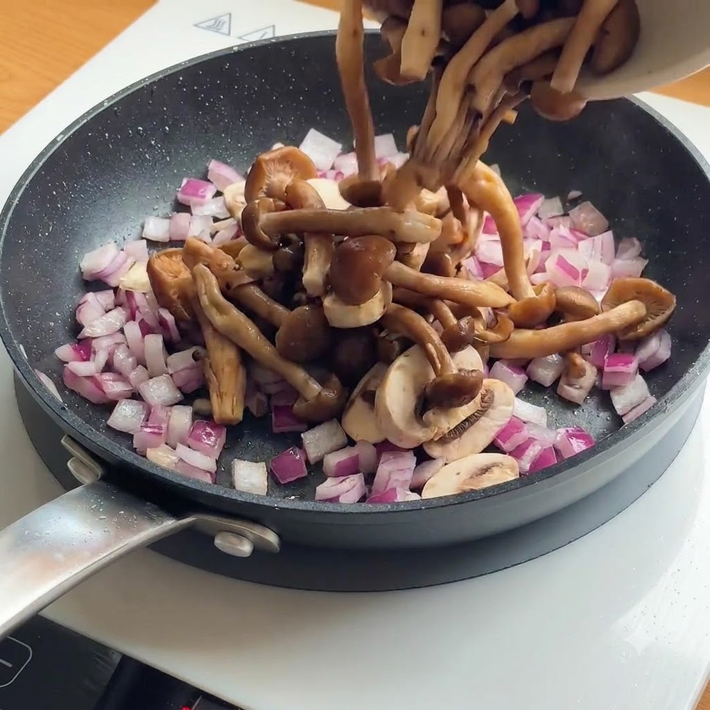 이미 구워진 닭고기가 있는 프라이팬에 썰어둔 버섯과 적양파를 넣는 모습.