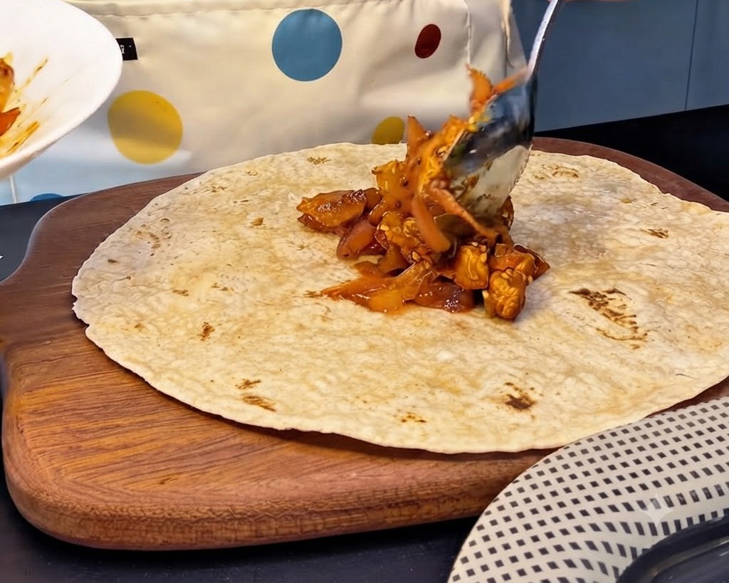 통밀 또띠아 중앙에 매콤한 닭갈비 김치 속재료를 큼직하게 덜어 올리는 모습