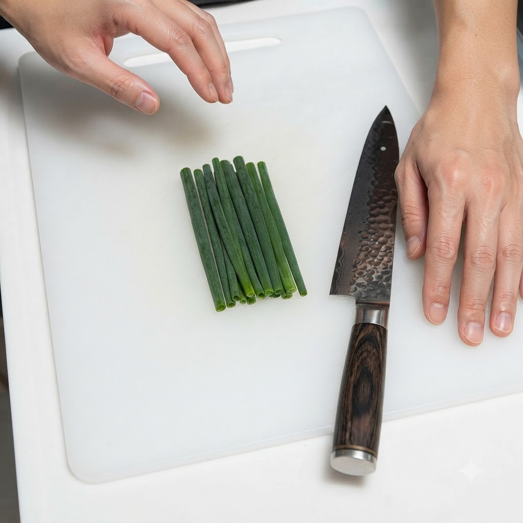 하얀 도마 위에 칼과 함께 가지런히 놓인 파.