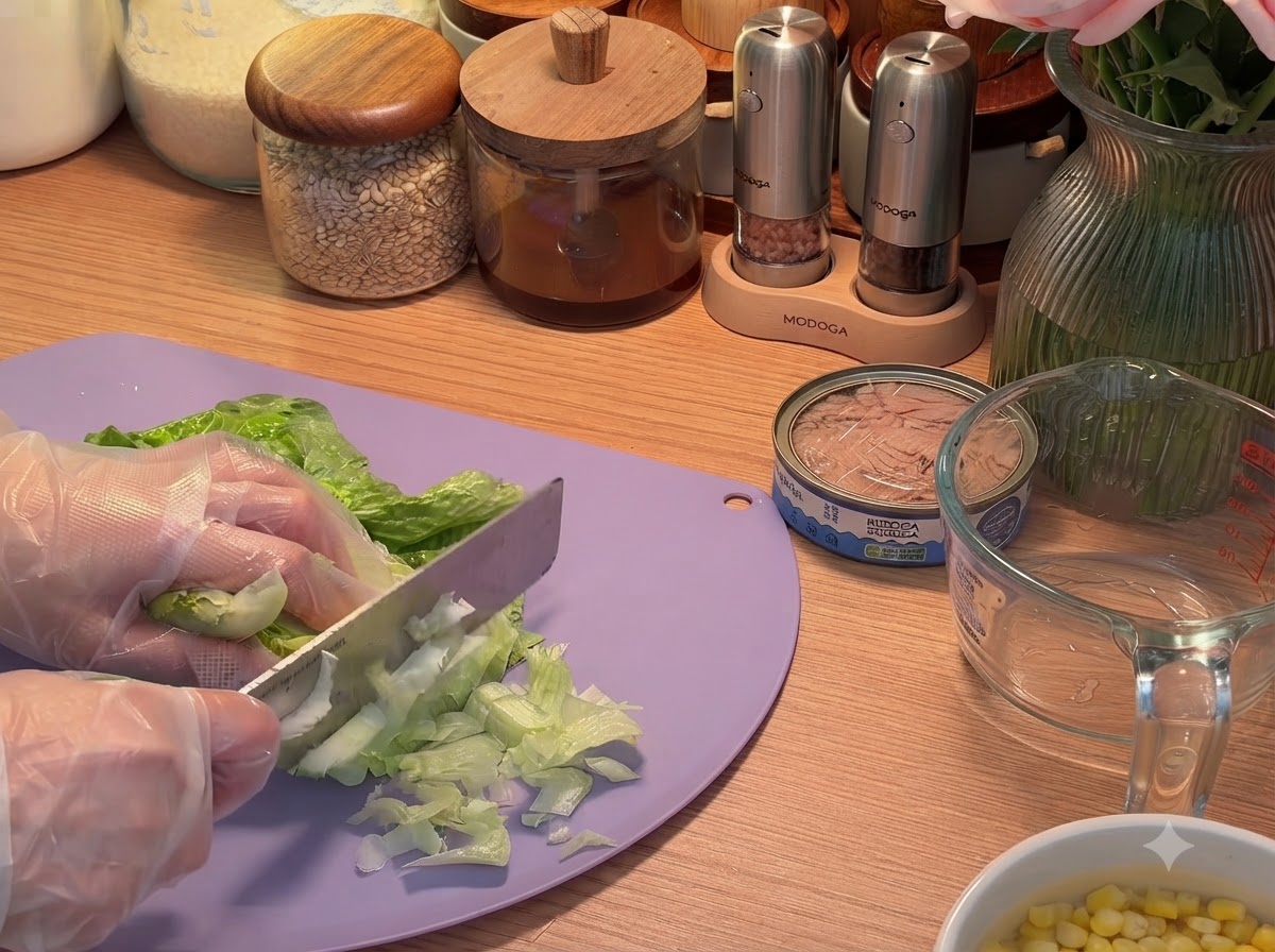 도마 위에서 칼로 상추 잎을 얇게 썰고 있습니다.