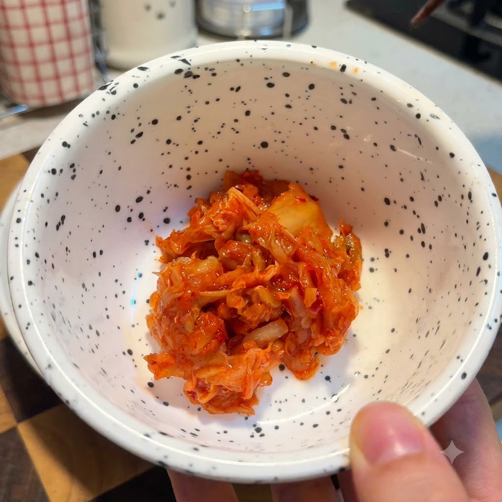 먹기 좋게 다진 밝은 빨간색 김치가 담긴 하얀색 물방울무늬 그릇.
