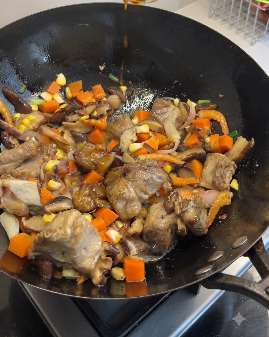 돼지갈비, 채소, 버섯, 옥수수가 담긴 웍 위로 진간장과 노두유를 위에서 흘려 넣는 모습.