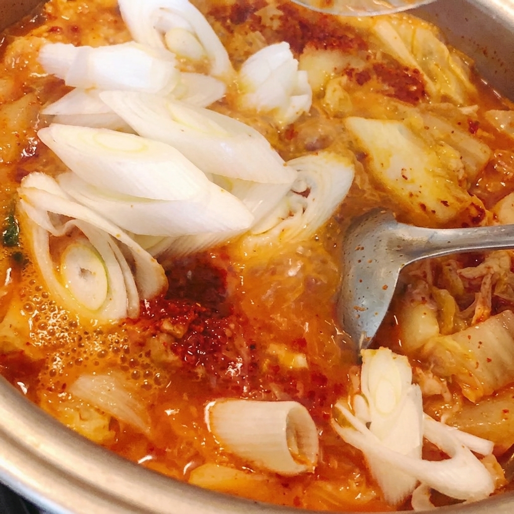 냄비에 썬 대파를 넣고 찌개와 함께 섞어주는 모습