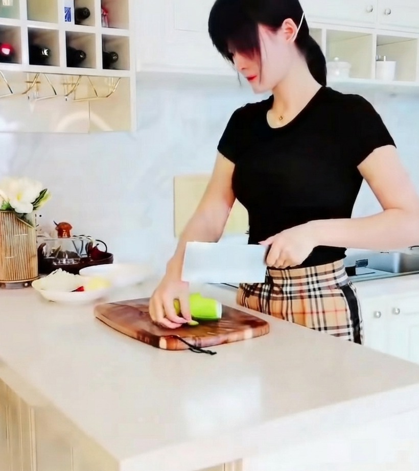 나무 도마 위에서 날카로운 칼로 초록색 애호박을 한 입 크기의 삼각형 조각으로 썰고 있는 클로즈업 사진.