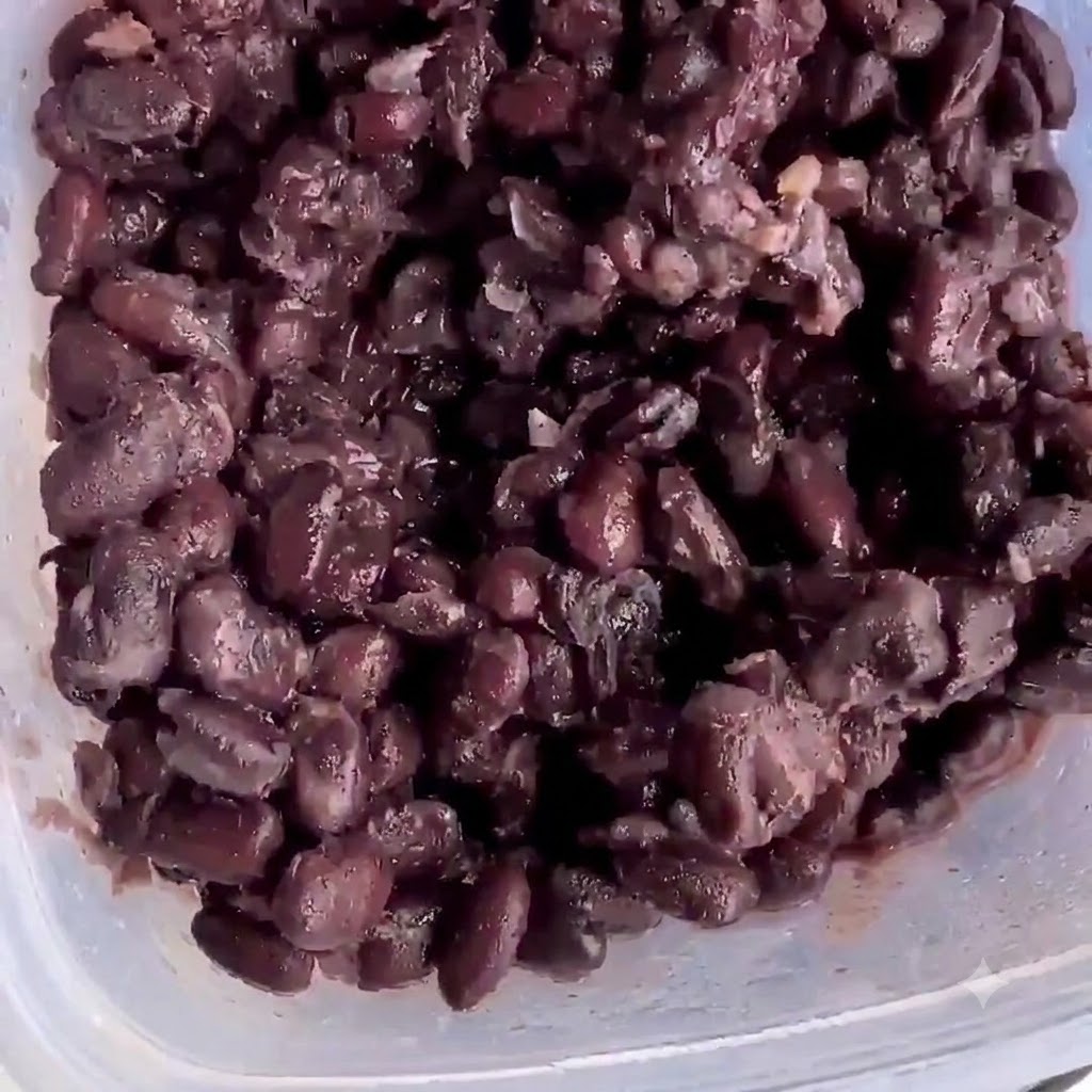 으깰 준비가 된 플라스틱 용기 안의 삶은 검은콩.