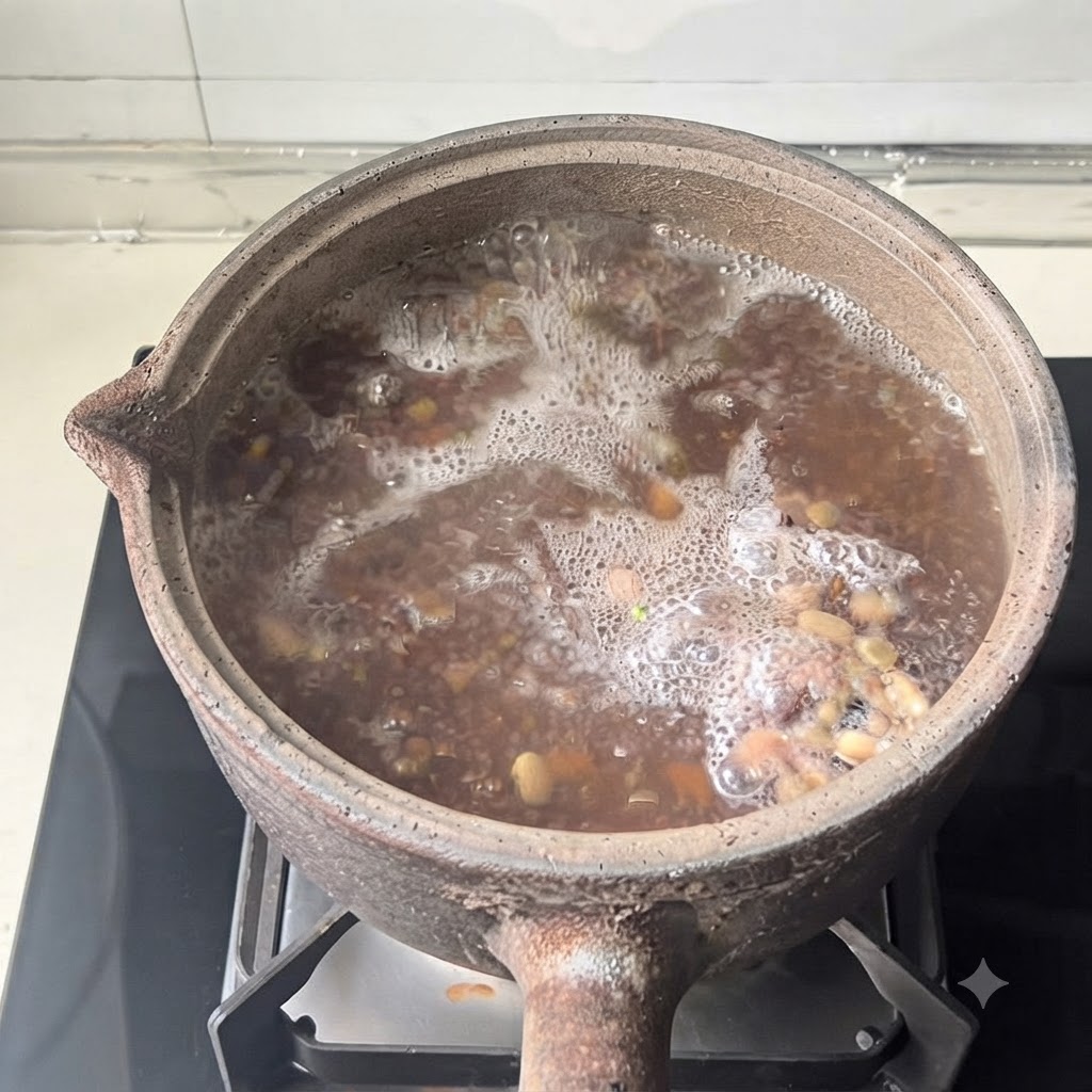 뚜껑이 닫힌 토기 냄비가 조리 과정 중에 현대적인 스토브 버너 위에 놓여 있는 모습.