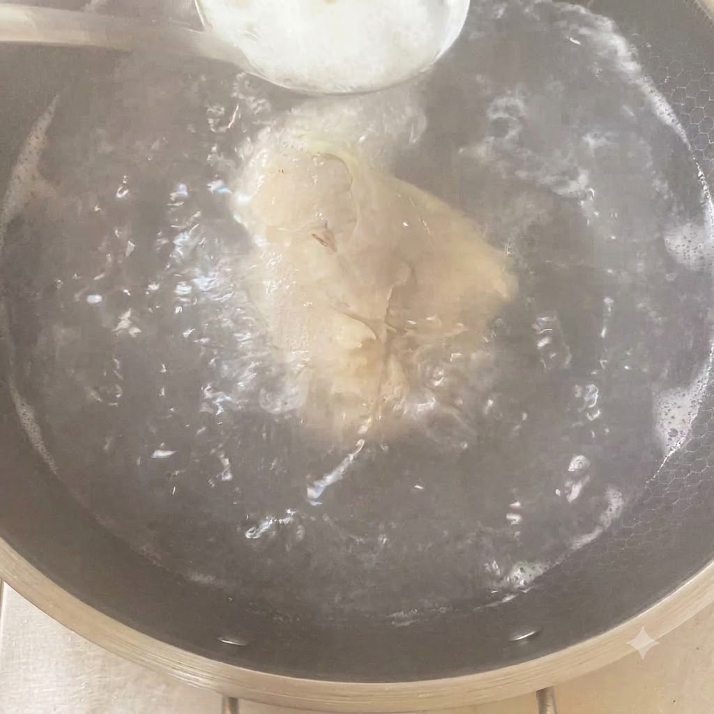 닭고기와 향채가 끓고 있는 냄비에 양념을 숟가락으로 넣는 모습.