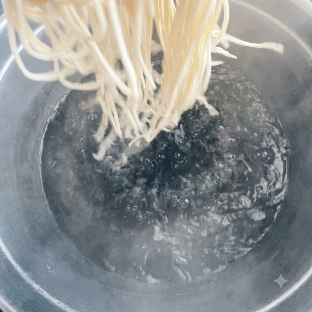 팔팔 끓는 커다란 냄비에 면을 넣는 모습.
