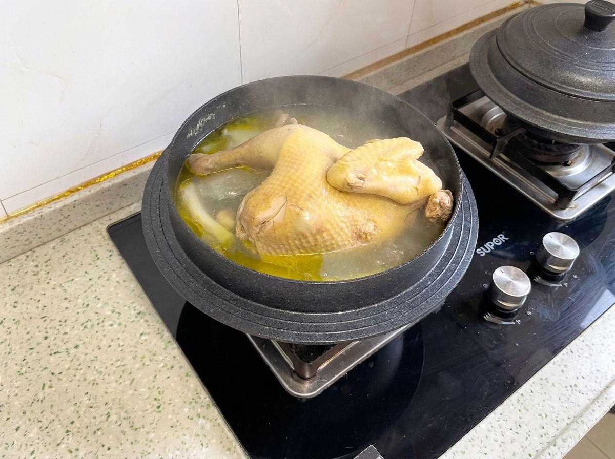 냄비 안에서 푹 삶아진 통닭을 먹기 좋게 자르는 모습