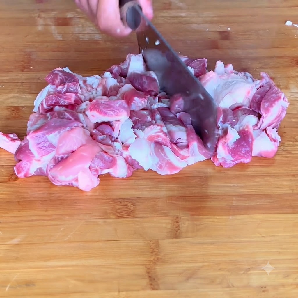 도마 위에서 돼지고기를 곱게 다져 고기 반죽으로 만드는 클로즈업 샷.
