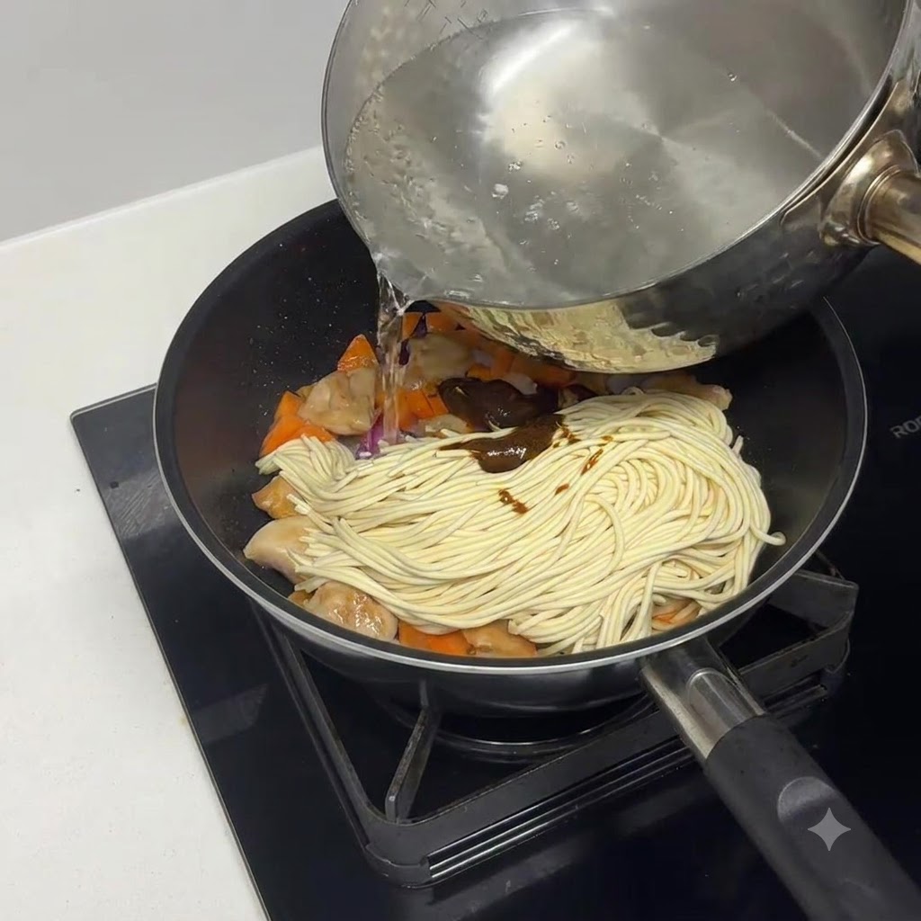 파스타, 닭고기, 카레 재료 위로 끓인 물을 붓는 모습.