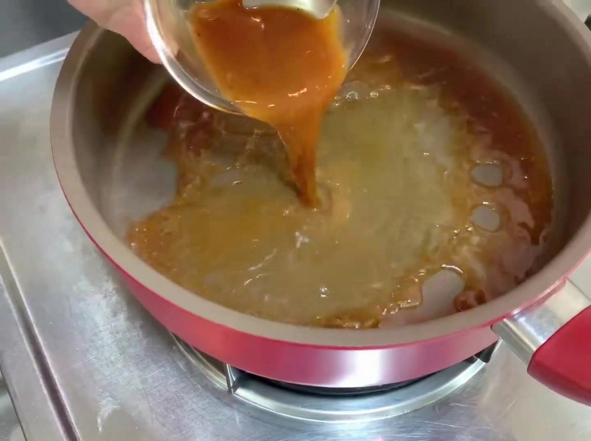 달궈진 팬에 흑후추 소스가 부어지며 거품이 이는 액체가 만들어지고 있습니다.