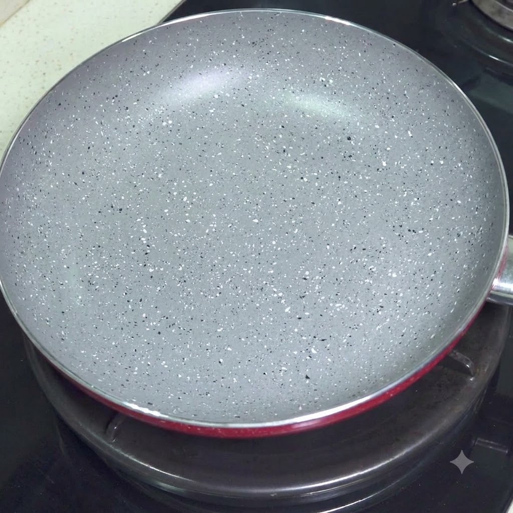 가스레인지 위에 올려진 빈 회색 코팅 프라이팬
