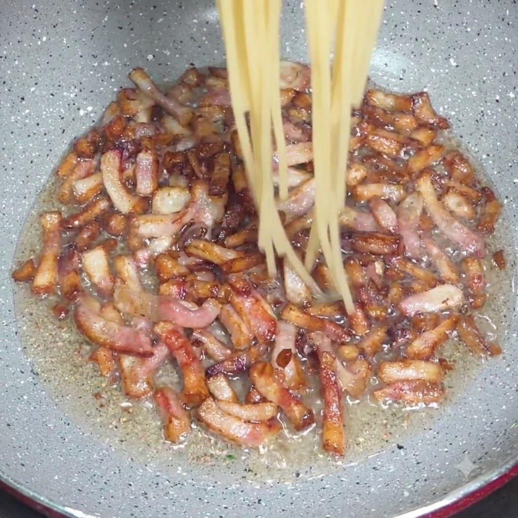 집게를 사용하여 익힌 스파게티 면을 바삭한 관찰레 조각이 있는 팬으로 옮기는 모습