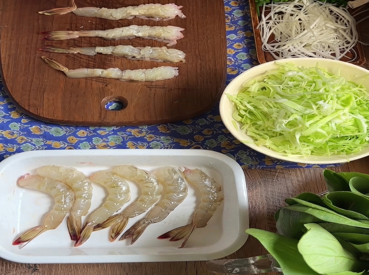배 쪽 힘줄을 끊어낸 후 나무 도마 위에 나란히 놓인 생새우들.