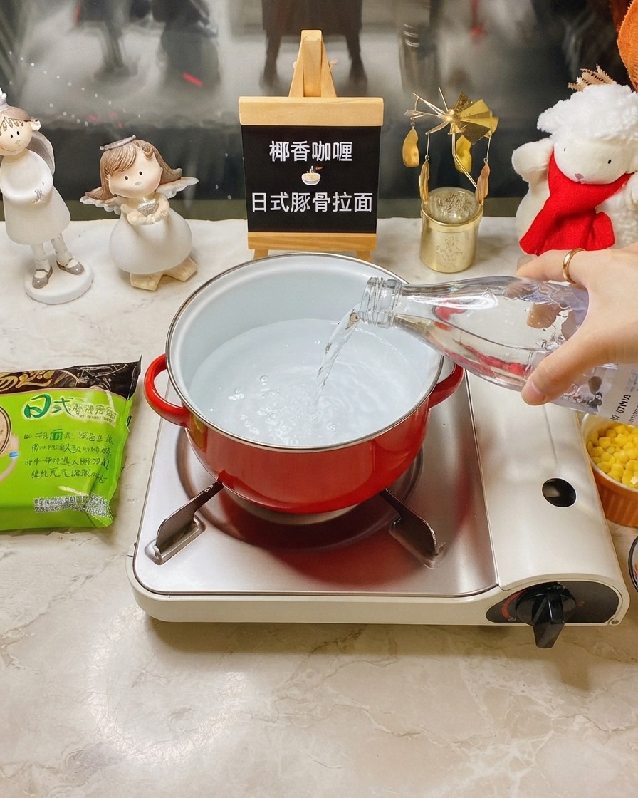 휴대용 가스버너 위 빨간 냄비에 투명한 병으로 물을 붓는 모습.