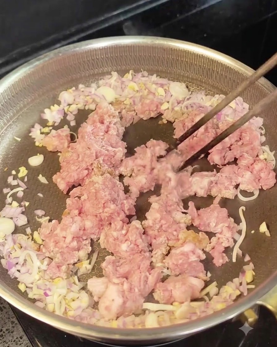 볶은 양파와 마늘을 가장자리로 밀어내고 가운데에 다진 생고기를 넣은 모습