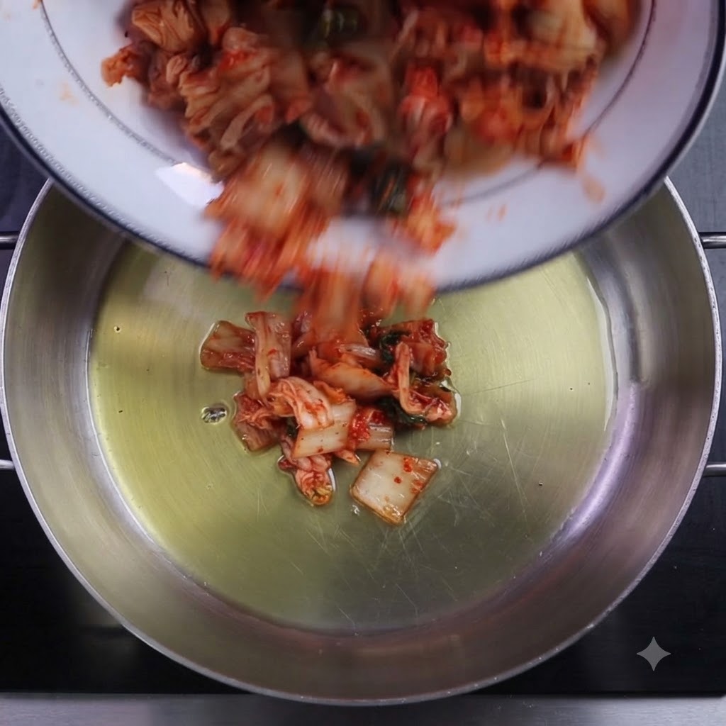 기름을 두른 냄비에 썬 김치와 고춧가루를 넣는 모습.