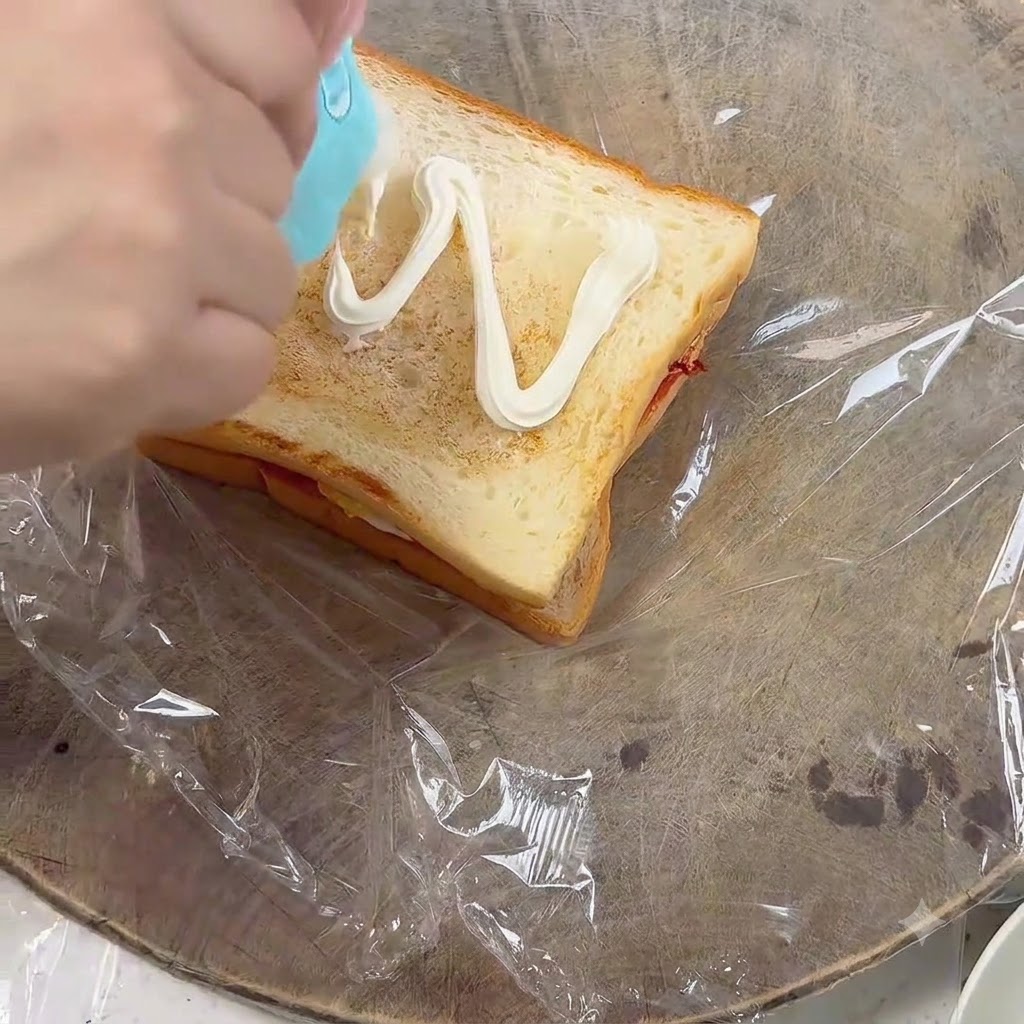 구운 식빵 조각 위에 지그재그 모양으로 짜이는 마요네즈.