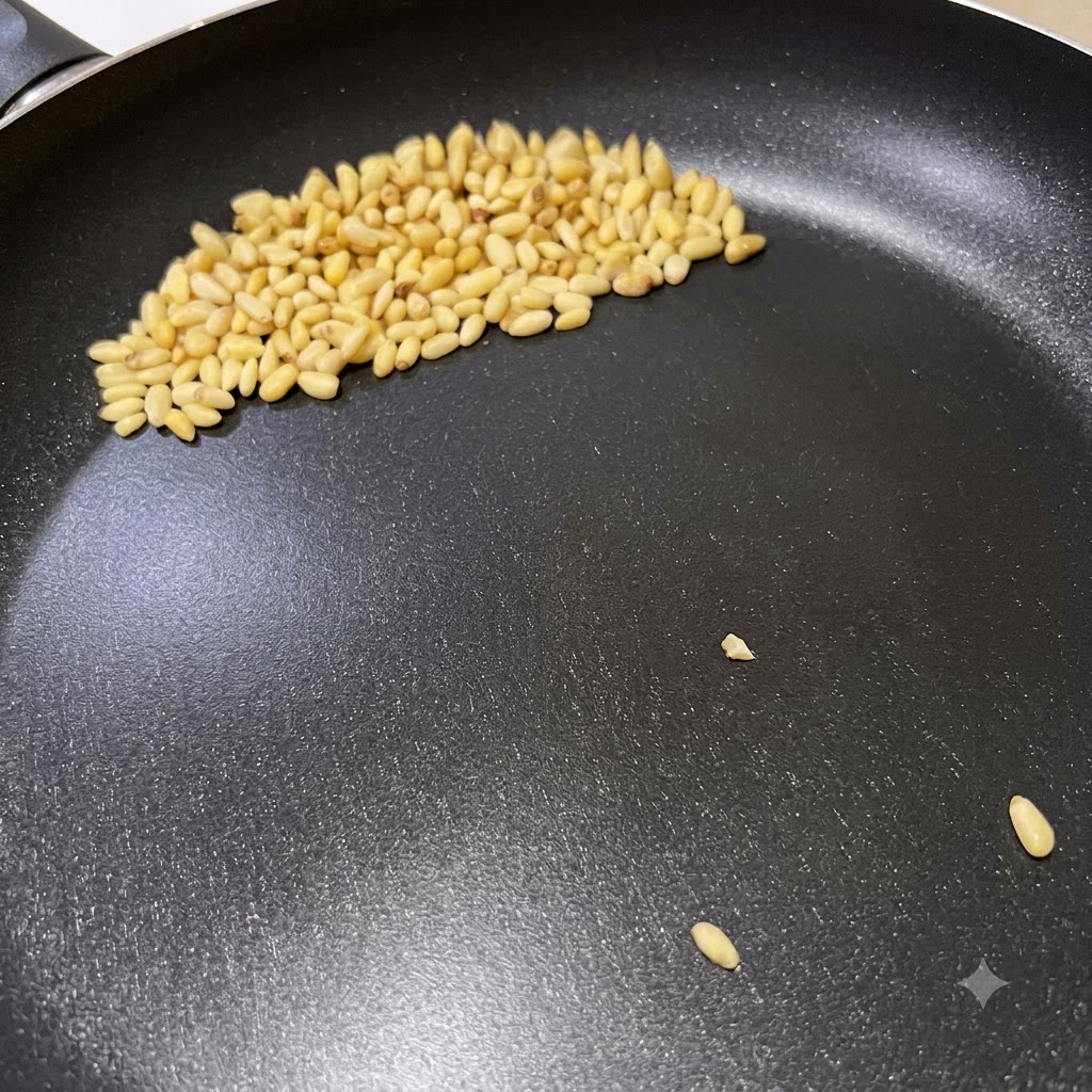 이탈리안 페스토 파스타 준비 과정에서 마른 프라이팬에 잣이 노릇하게 구워지는 모습.