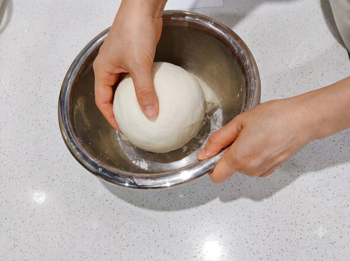 투명하고 직사각형인 발효 용기 안에 성형된 두 개의 반죽이 나란히 놓여 있는 모습.