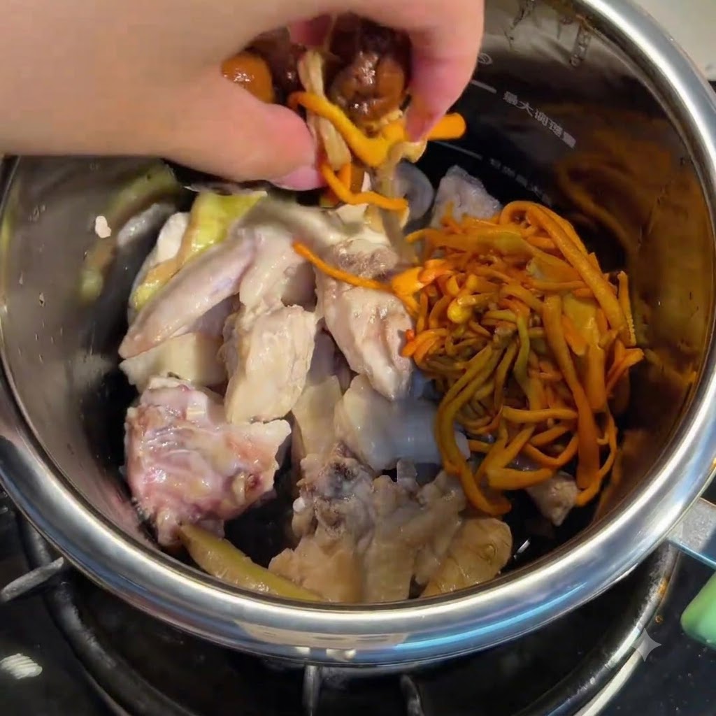 닭고기가 담긴 냄비에 불린 버섯과 동충하초를 손으로 넣는 모습.