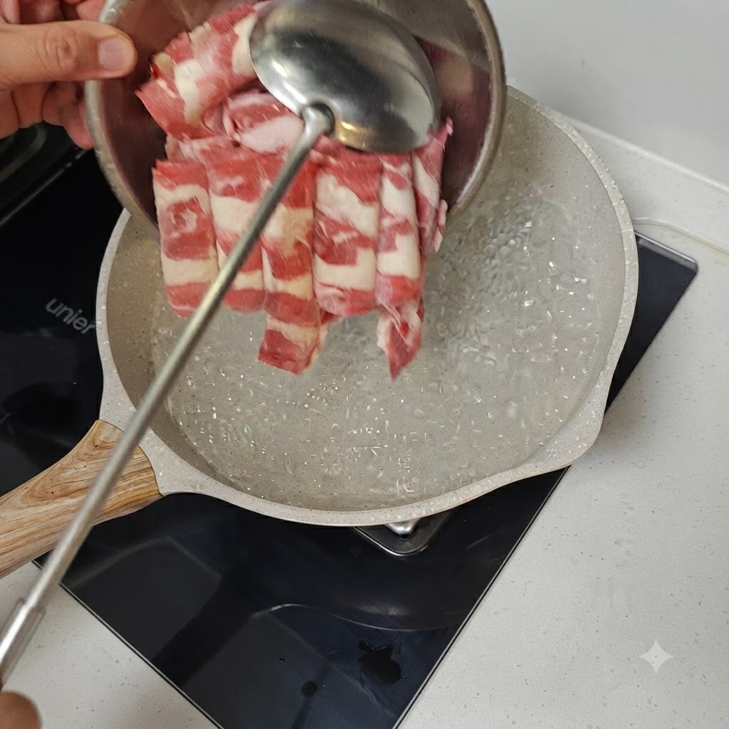 금속 국자를 이용해 펄펄 끓는 물이 담긴 팬에 얇게 썬 소고기를 넣고 있는 모습.