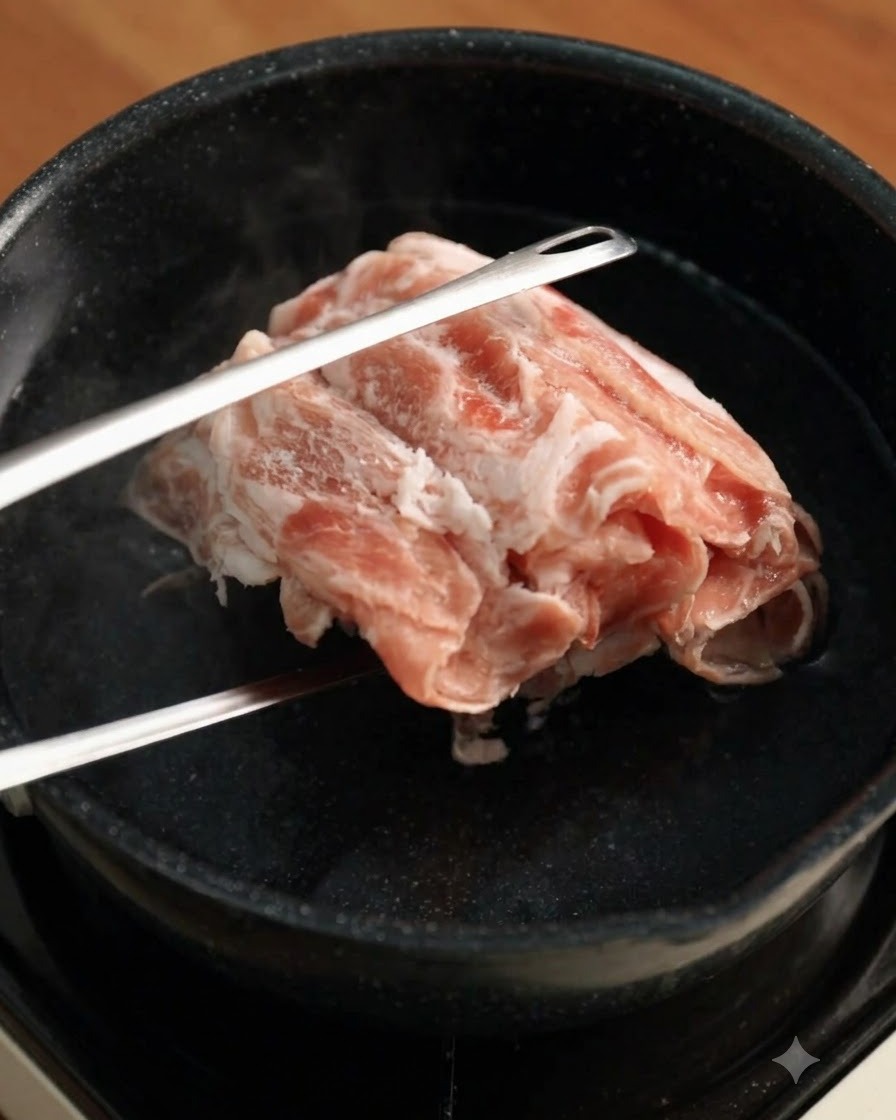 집게를 사용해 끓는 물에 냉동 소고기 슬라이스를 넣는 모습.