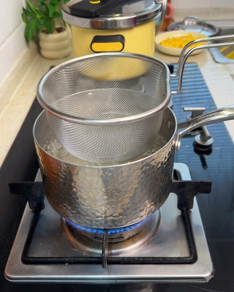 생강과 맛술을 넣고 끓는 냄비에 소고기를 담은 메쉬망 바구니를 넣고 데치는 모습.