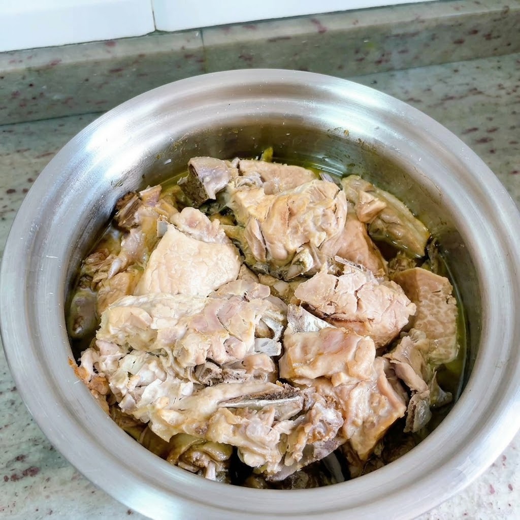 압력솥 뚜껑이 제거되어 풍부한 육즙에 잠긴 조리된 오리고기가 드러난 모습.