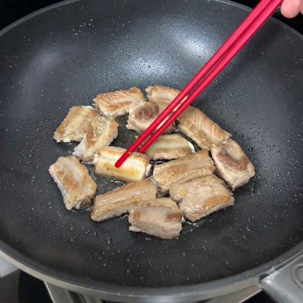 젓가락으로 뒤집어가며 팬에서 노릇하게 구워지고 있는 돼지갈비.