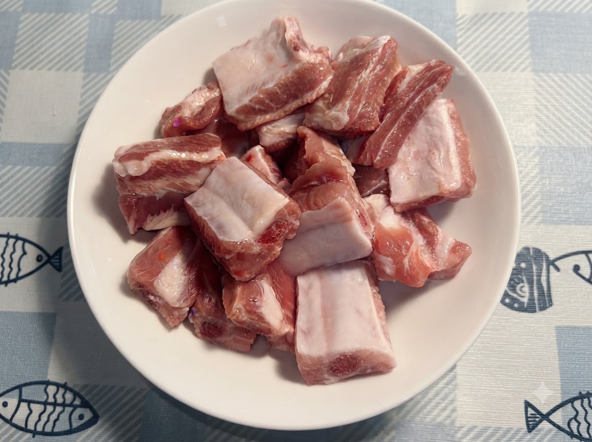 작은 흰색 숟가락을 사용하여 접시에 담긴 생 돼지 갈비 위에 소금을 넣고 있는 모습.