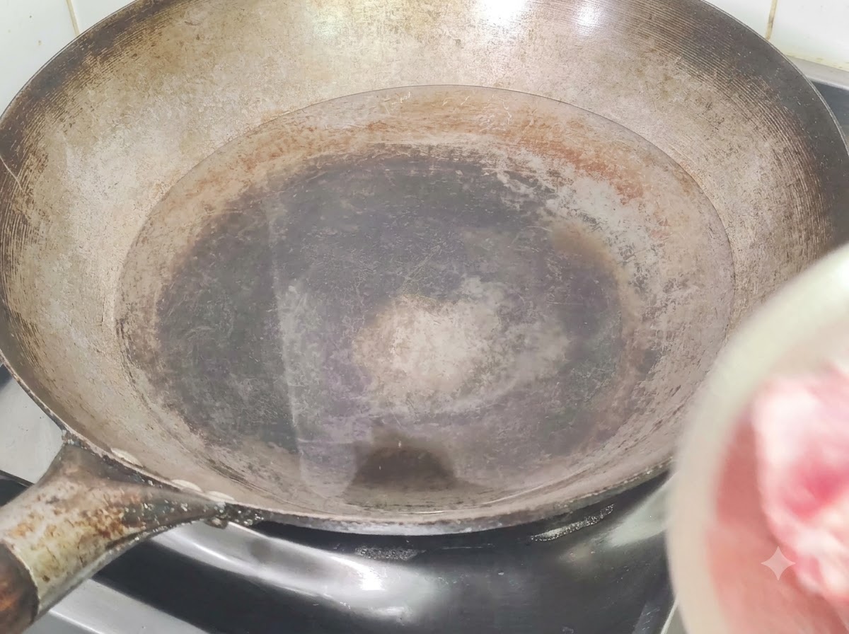 찬물, 생강, 맛술을 넣은 웍에 돼지갈비를 넣어 데치는 모습
