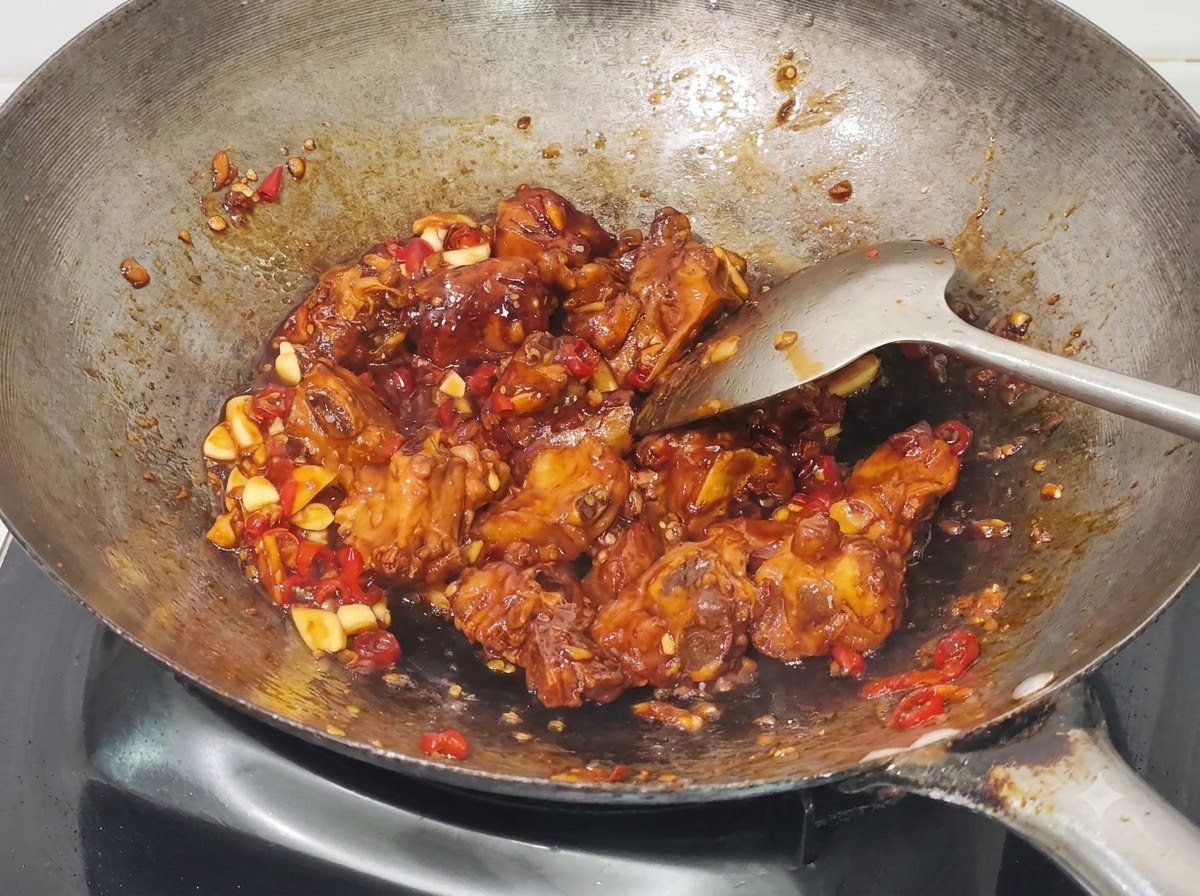 완성된 허니 갈릭 돼지갈비 조림에 송송 썬 대파를 넣어 섞는 모습