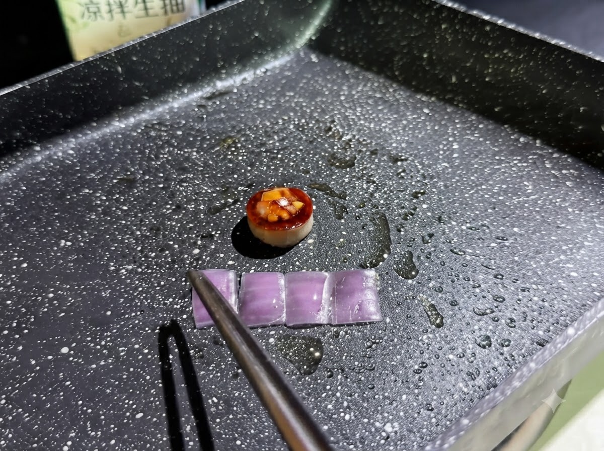 기름칠한 팬에서 채워진 버섯 링 옆으로 네 개의 작은 직사각형 적양파 조각이 튀겨지는 모습.